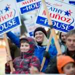 Rep. Cathy Muñoz waves to evening commuters on the eve of the national and state elections Nov. 7, 2016.