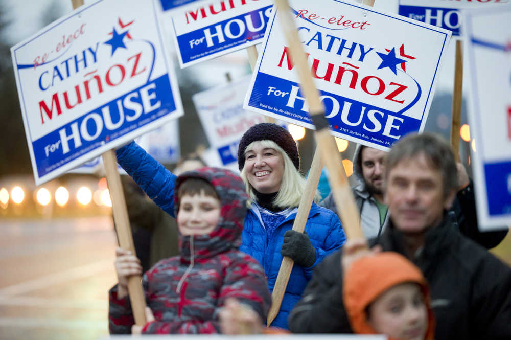 Rep. Cathy Muñoz waves to evening commuters on the eve of the national and state elections Nov. 7, 2016.