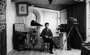 A self portrait of Benjamin Haldane inside his photo studio in Metlakatla. Dangeli points out objects that are indications both of his photographic  and musical careers. His arm rests on a model totem, emphasizing his heritage. "He chose to visually connect to his body a model totem pole with his Lax Gibou (Wolf Clan) crest represented by the bottom figure," she wrote. "Both physically and metaphorically, he is supported by Tsimshian cultural values and beliefs and gazes directly at the viewer to assert their importance."  Donor: Melvin Charles, THS 89.2.14.21