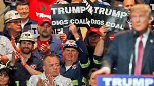 In this file May 5, 2016 photo, coal miners wave signs as Republican presidential candidate Donald Trump speaks during a rally in Charleston, West Virginia. Trump's election could signal the end of many of President Barack Obama's signature environmental initiatives. Trump has said he loathes regulation and wants to use more coal and expand offshore drilling and hydraulic fracturing.