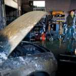 Automotive business owner Carson Knight takes stock inside his automotive shop on Thursday after a late night fire destroyed a number of businesses in the building located behind the Sandbar on Industrial Boulevard.