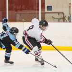 Juneau-Douglas' Niko Hebert, right, races Hutchison's Russell Savok to the goal at Treadwell Arena on Friday, Nov. 18, 2016.