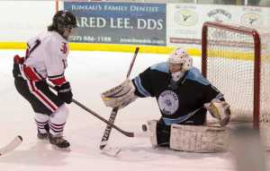 Juneau-Douglas' Bill Bosse challenges Hutchison's goalie Alayah Brunty at Treadwell Arena on Friday, Nov. 18, 2016.