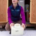 Marissa Capito, an engineering assistant at the Mendenhall Water Treatment Plant, shows a sample collector at the plant on Wednesday. Home owners putting food waste and oil down the drain cause major issues on how well the treatment plant works.
