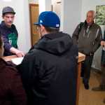 Mayor Ken Koelsch, center, stands and watches the first marijuana sales in Juneau with Giono Barrett, right, as James Barrett helps customers during a invitation opening of Rainforest Farms store on Wednesday, Nov. 23, 2016. The brothers have been working for over two years to opening their store.