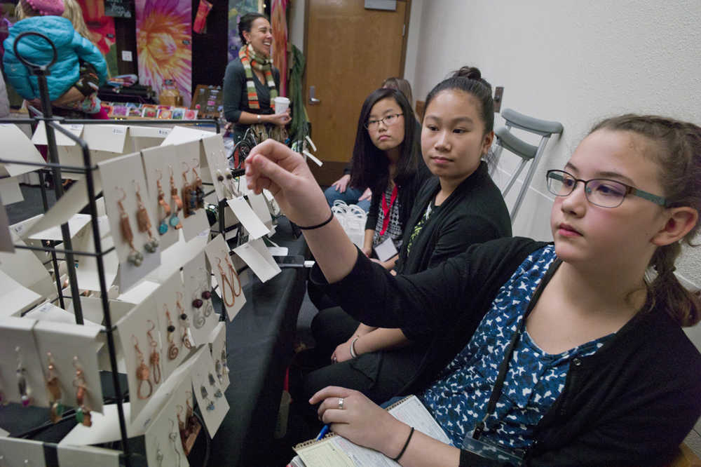 Solveig Wolter, 11, right, Molly Brocious, 12, center, and Ruchi Haight, 12, wait for customers at the jewelry booth at Public Market in Centennial Hall on Friday.