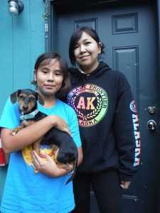 Geneva Anowlic-Okitkon, 18 years old at the time of this photo, stands with her little sister, left, on July 25. Anowlic-Okitkon is currently recovering in an Anchorage hospital after she was shot in the head in mid October.