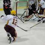 The hockey puck squeezes by Juneau-Douglas High School goalie Wolf Dostal (30) during a game against Dimon High School's JV hockey team on Friday at Treadwell Ice Arena.