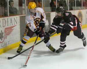 Dimon High School's Caleb Berntsen (37) and Juneau-Douglas High School's Cameron Smith (6)battle for the puck during a game at Treadwell Ice Arena on Friday