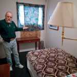 Charles Cotten Jr., the new manager of the Bergmann Hotel, shows off a recently remodelled room that rents for $600 per month.
