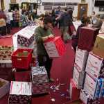 Enrique Sanchez decorates boxes with Rotary members and local real estate agents as part of the Racheal MacLeod Christmas Dinner Box Project at The Salvation Army Church on Monday, Dec. 19, 2016. The boxes, which will contain all the ingredients for a holiday dinner, will be available Thursday and Friday to 360 local families. The project is coordinated by the three Rotary clubs and the Rotaract club of Juneau.