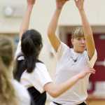 Caitlin Pusich, right, passes over teammate Meghna Bathija during practice at JDHS on Wednesday, Dec. 14, 2016.