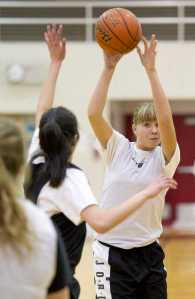 Caitlin Pusich, right, passes over teammate Meghna Bathija during practice at JDHS on Wednesday, Dec. 14, 2016.
