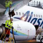 FILE - In this Monday, Nov. 14, 2016, photo, fueling manager Jarid Svraka looks on as he fuels an Alaska Airlines Boeing 737-800 jet with a new, blended alternative jet fuel, at Seattle-Tacoma International Airport in SeaTac, Wash. On Tuesday, Dec. 6, 2016, Alaska Airlines said it has won government approval to buy rival Virgin America after agreeing to reduce its flight-selling partnership with American Airlines. (AP Photo/Elaine Thompson, File)