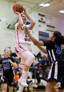 Juneau-Douglas's Caitlin Pusich lays the ball up against Thunder Mountain's Kyra Jenkins Hayes in the Capital City Classic at JDHS on Tuesday, Dec. 27, 2016.