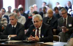 FILE - In this Dec. 15, 2016 file photo, Stephen W. Parker, left, co-owner and co-publisher of New Jersey Hills Media Group, listens as Richard Vezza, publisher of the Star-Ledger newspaper, addresses members of the New Jersey Assembly Appropriations Committee, as the committee considers among others, legislation to scrap a requirement that legal notices be published in newspapers, after a Senate budget committee greenlighted the legislation earlier in the day, in Trenton. As classified advertising, once the lifeblood of newspapers, has dried up, one constant has remained: A thick daily listing of government public notices. But legislative fights in New Jersey and elsewhere have put that tradition at risk. (AP Photo/Mel Evans, File)