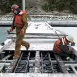 Jeff Trucano, left, and Sam Miller, of Trucano Construction, work at installing lighting fixtures on the new dock in Douglas Harbor on Wednesday, Jan. 4, 2017.