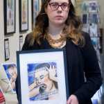 Christine Carpenter holds one of her artworks in the Alaska Robotics Gallery on Friday, Jan. 6, 2017, she made after being raped in Italy.