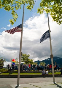 Flags fly at half-staff as Juneau residents attend a noon vigil Monday at Marine Park for the victims of the Orlando shootings over the weekend.