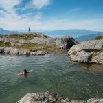 Solana Ashe swims in an snow melt pond at the top of Mount Jumbo on Monday while David Flory takes in the view looking toward the backside of Douglas Island.