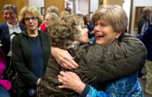 Mary Becker, right, is congratulated by Rosemary Hagevig in the Assembly chambers after retaining her Assembly seat during Tuesday's municipal election.