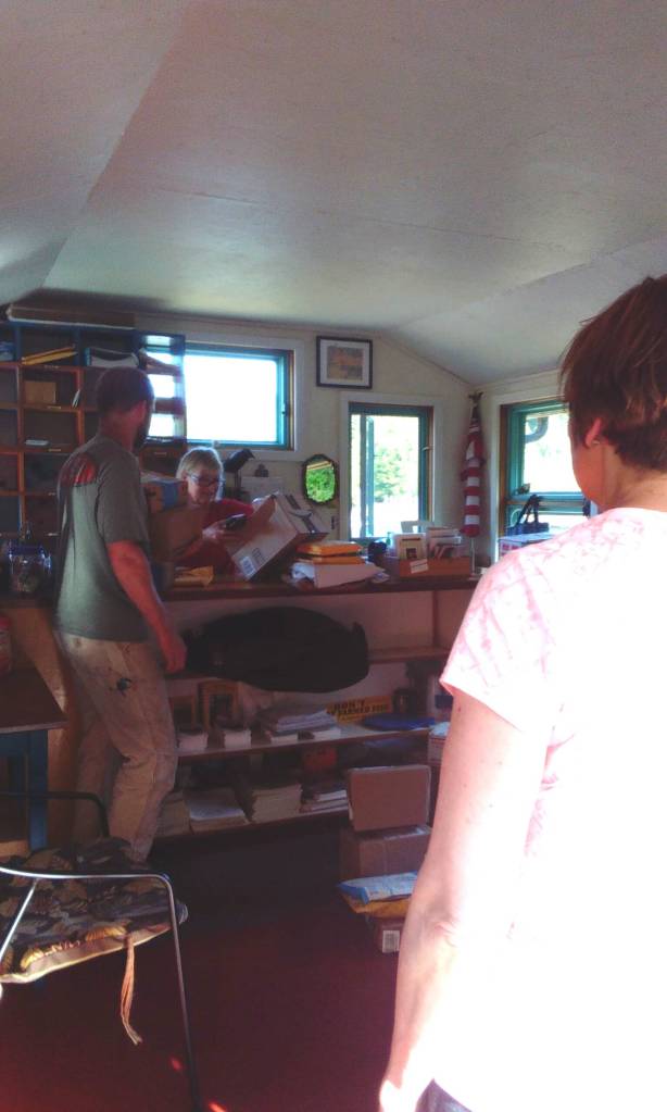 Locals in the Meyers Chuck post office waiting for post mistress Cassie Peavey to sort and scan their mail. (Tara Neilson | For the Capital City Weekly)