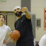 Carlos Boozer talks to Cooper Kriegmont at his basketball camp last August at the Juneau-Douglas High School gym. (Nolin Ainsworth | Juneau Empire File)