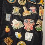 Tom Karpstein, 70, show a portion of his collection of baseball tournament pins as he talks Thursday, August 2, 2018, about his long baseball umpiring role in Juneau. (Michael Penn | Juneau Empire)