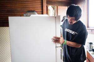 Russell James reviews the energy load for home appliances during a home energy audit demonstration at a Kake home in July. (Courtesy Photo | Bethany Goodrich)