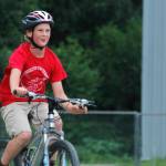 Reed Maier, 11, approaches the finish line with a smile at the Douglas Dirt Derby on Saturday, Aug. 4, 2018 at Savikko Park in Douglas. Maier finished first in his age group, and the event raised $6,000 for the American Diabetes Association. (Alex McCarthy | Juneau Empire)