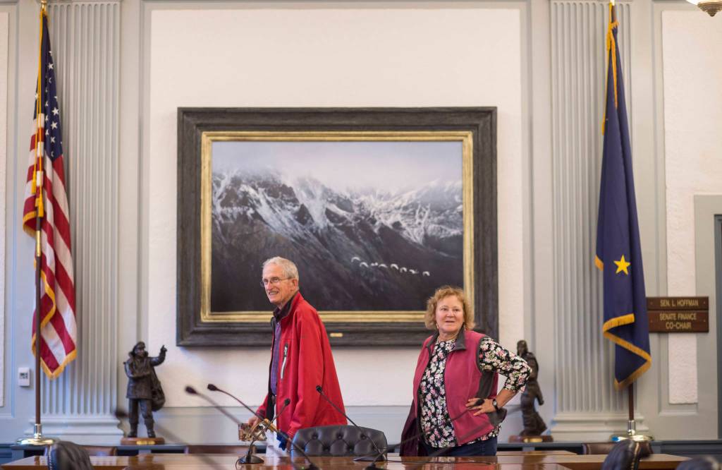 Bobby Lee Daniels, left, and Barbara Sheinberg view the artwork in the Senate Finance room of the Capitol during First Friday. The painting, The Holy Spirit, is by Randall Compton of Fairbanks. (Michael Penn | Capital City Weekly)