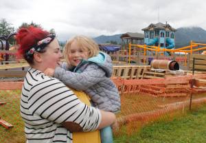 Lilah Gaguine, 4, laughs as her mother Becca holds her near Project Playground on the first day of the community build, Aug. 8, 2018. Lilah saved up her allowance for a year to donate to the rebuild, and was invited as an honorary volunteer. (Alex McCarthy | Juneau Empire)