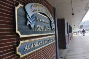 In this June 2017 photo, a pedestrian walks by City Hall. (Alex McCarthy | Juneau Empire File)