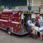 A Capital City Fire/Rescue crew transports a cruise ship passenger off the Radiences of the Seas downtown on Tuesday, August 14, 2018. (Michael Penn | Juneau Empire)