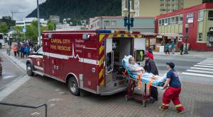 A Capital City Fire/Rescue crew transports a cruise ship passenger off the Radiences of the Seas downtown on Tuesday, August 14, 2018. (Michael Penn | Juneau Empire)