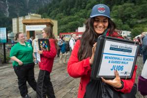 Maria Covarrubian, right, Maddie Simbirdi, center, and Kourtney Howard wait to direct cruise ship passengers to their excursions downtown on Tuesday, August 14, 2018. (Michael Penn | Juneau Empire)
