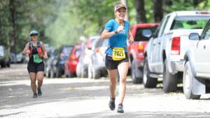 Kristy Petovello, of Whitehorse, sprints down Basin Road toward the finish of her 25-kilometer race during the Nifty 50 on Saturday, Aug. 11, 2018. Petovello finished third for women, behind Rachel Phelps, and Suzanne Sauerteig. (Nolin Ainsworth | Juneau Empire)