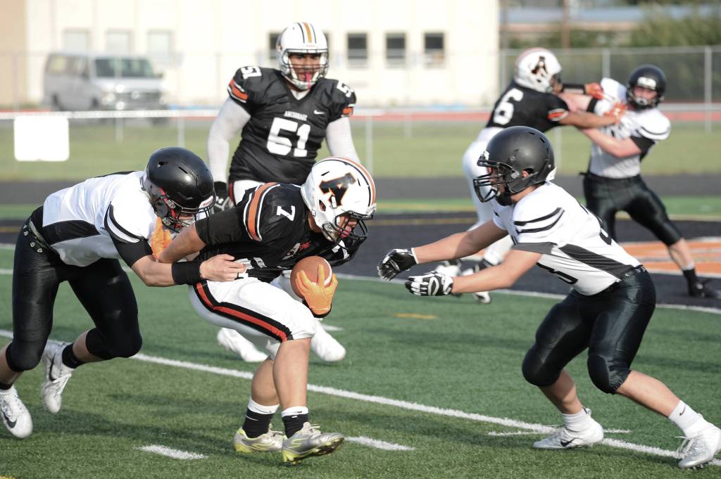 Wests Lewis Malala is brought down by Juneaus Cooper Kriegmont and Lewis Mojica. (Michael Dinneen | For the Juneau Empire)