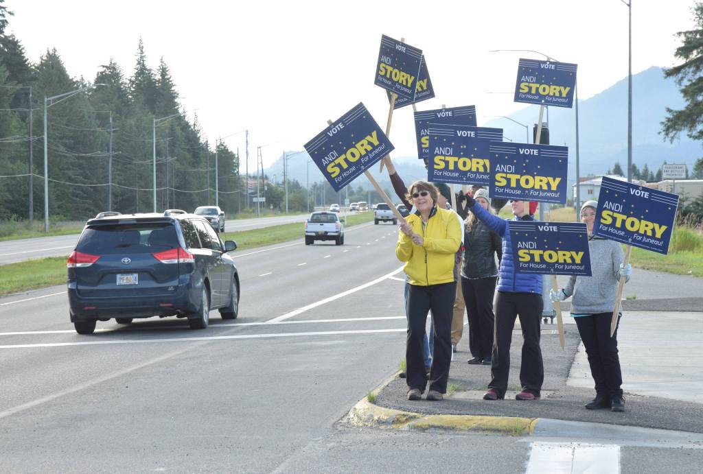 Supporters of Andi Story, Democratic candidate for House District 34, wave signs Tuesday, Aug. 21, 2018 at the McNugget intersection. (James Brooks | Juneau Empire)