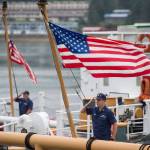 Flags are raised on U.S. Coast Guard buoy tenders for reveille before the start of the Buoy Tender Olympics at Station Juneau on Wednesday, Aug. 22, 2018. (Michael Penn | Juneau Empire)