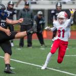 Juneau Footballs Kurtis Lee, left, punts the ball out of reach of Easts Jordan Holland at Adair-Kennedy Memorial Field on Saturday, Aug. 25, 2018. East won 40-0. (Michael Penn | Juneau Empire)