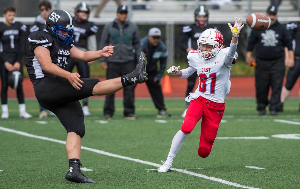 Juneau Footballs Kurtis Lee, left, punts the ball out of reach of Easts Jordan Holland at Adair-Kennedy Memorial Field on Saturday, Aug. 25, 2018. East won 40-0. (Michael Penn | Juneau Empire)