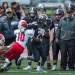 Juneau Footballs Cody Morehouse, center, is forced out of bounds by Easts Alex Hinton at Adair-Kennedy Memorial Field on Saturday, Aug. 25, 2018. East won 40-0. (Michael Penn | Juneau Empire)