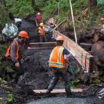 Trail Mix crew works as parts of a new bridge are lowered by helicopter at Paris Creek on the Treadwell Ditch Trail on Thursday, July 6, 2017. (Michael Penn | Juneau Empire File)