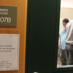 People attending an Alaska Marijuana Control Board meeting Wednesday in Anchorage mill about the room at the University of Alaska Anchorage during a break.