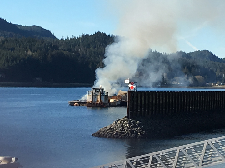 A tugboat anchored just outside Aurora Harbor burns on Monday afternoon.