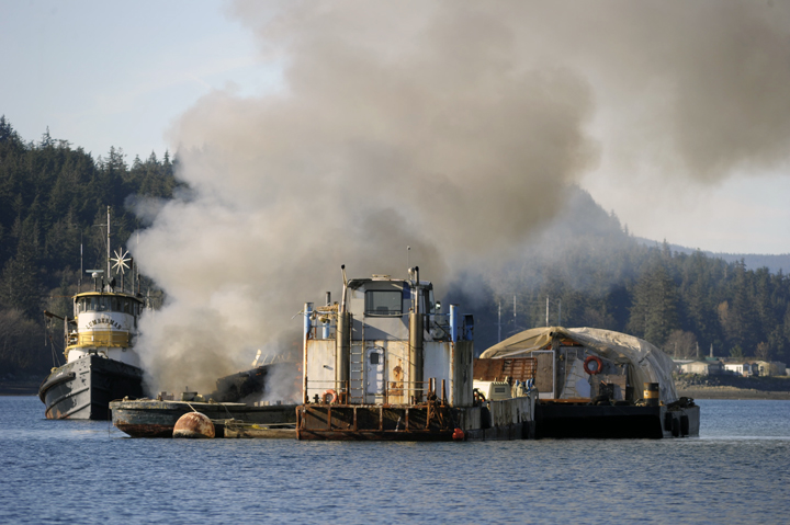 A tugboat anchored just outside Aurora Harbor burns on Monday afternoon.
