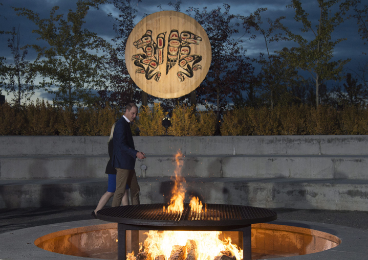Britain's Prince William, the Duke of Cambridge, walks past a fire outside the cultural center in Whitehorse, Yukon, Tuesday.