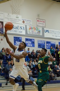 Thunder Mountain's RJ Manning drives passed Service's Jason Lombard for a layup during their game at TMHS on Friday. Service won 66-63 in overtime.