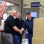 Principal Jim Thompson accepts boxes of donated food for Floyd Dryden Middle School students.